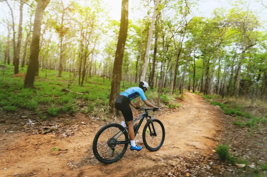 A Man Riding His Bicycle on A Dirt Trail