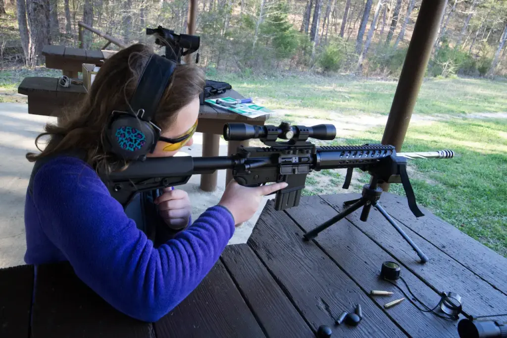 Teenage Girl at Shooting Range Firing an AR-15 Rifle 